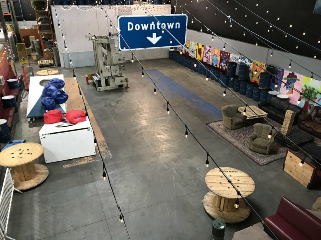 view of the brewery with giant cornhole and various seating arrangements