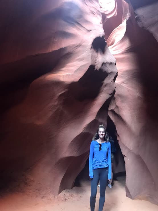 the walls of Antelope Canyon forming a face with a woman (me) standing underneath