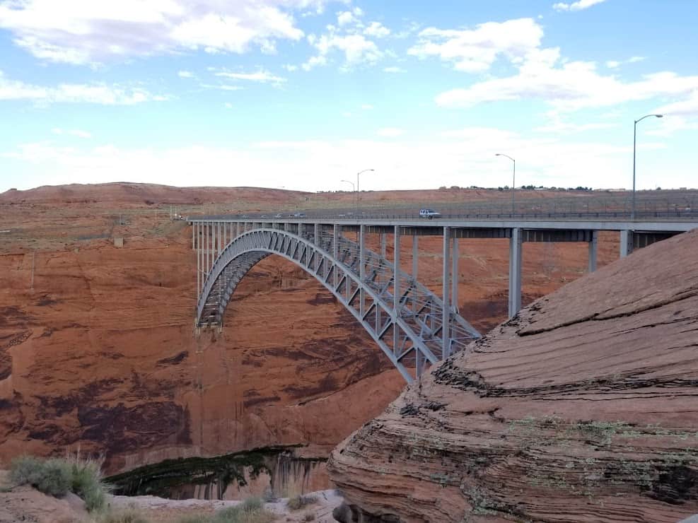 The Glen Canyon Dam Bridge stretches over Lake Powell's red cliffs. 