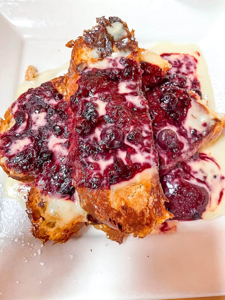 a decadent portion of french toast made of baguettes smothered in a berry compote and creme anglaise from Portage Bay, Seattle