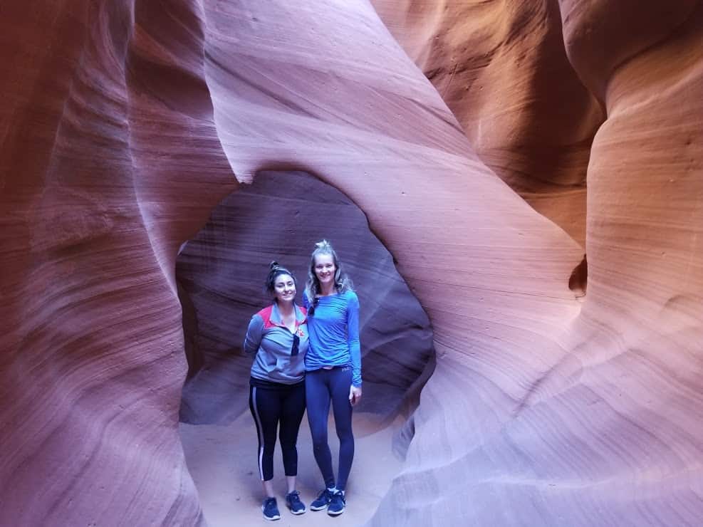 two women standing under an arch in Antelope Canyon 