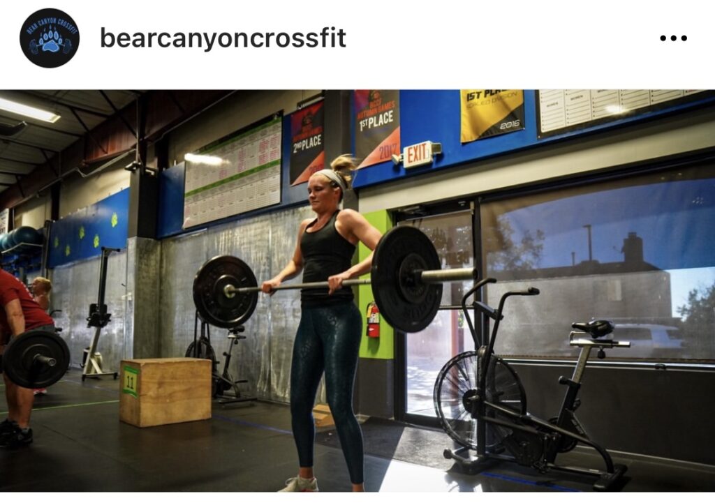 a blonde woman in a gym lifting weights