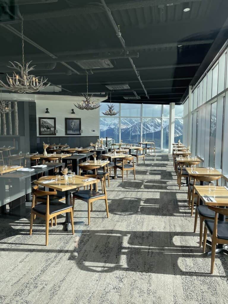 the empty but beautiful Sky Bistro dining room shows snow-capped mountains out the dining room windows 