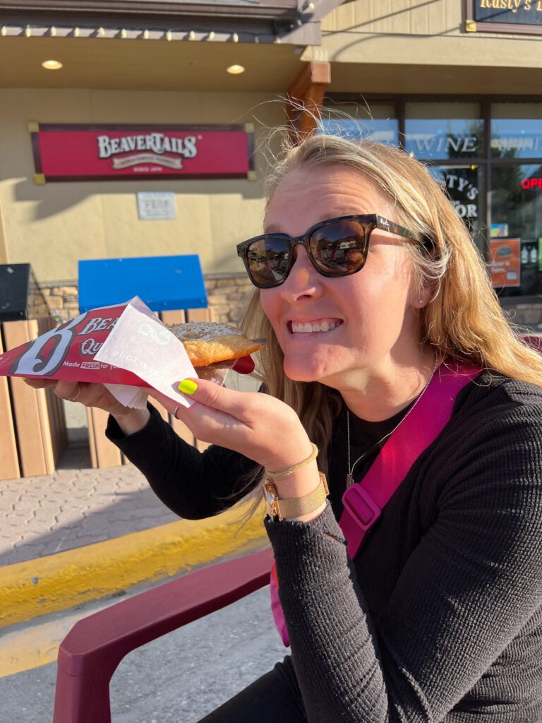 the author holds up her pastry and smiles