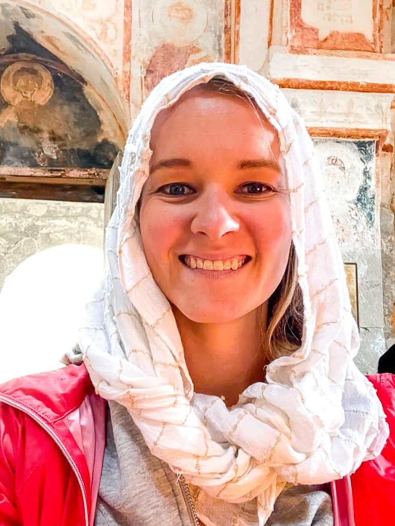 a woman smiles while wearing a head covering 